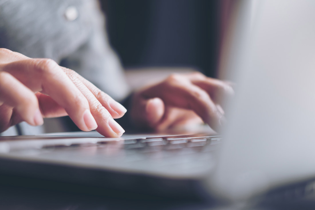 Close up of hands typing on a keyboard